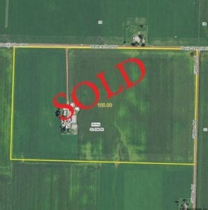 Drone view of farmland, "SOLD" laid over top in bold red text